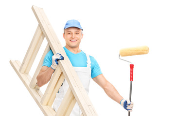 Wall Mural - Young house painter holding a paint roller and a wooden ladder