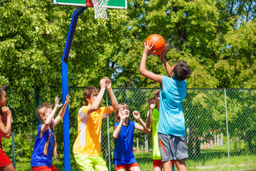 Group of teenagers play basketball on playground