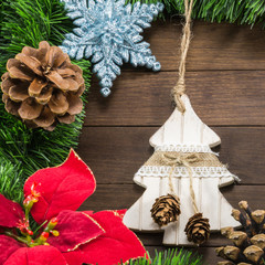 christmas decoration with pine cones, treeand a star on wooden b