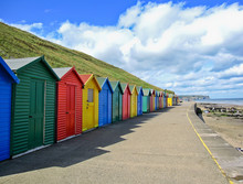 Row Of Colourful Beach Huts In Whitby, Yorkshire, England.