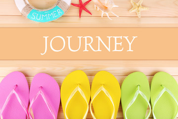 Sticker - Journey concept. Bright flip-flops on wooden background