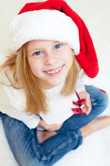 Beautiful blonde little girl, sitting on the floor and holding C