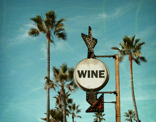 Wall Mural - aged and worn vintage photo of wine sign on beach with palm trees