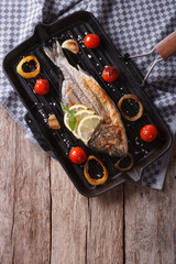 Wall Mural - Dorado fish cooking on the grill pan close-up. vertical top view
