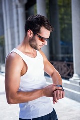 Poster - Handsome athlete with sunglasses setting heart rate watch