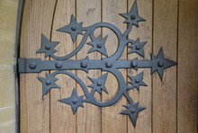 Ornate Metal Hinge On Brown Wooden Door