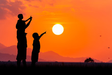 Silhouette Of Asian Little Boy Point To The Sun At Sunset Backgr