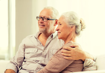 Wall Mural - happy senior couple sitting on sofa at home