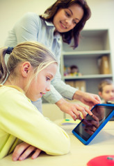 Canvas Print - little girl with teacher and tablet pc at school