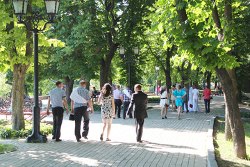 People have a rest in park with greater trees