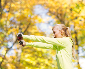 Wall Mural - sporty woman with light dumbbells outdoors