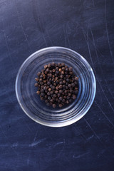 Canvas Print - Black pepper in bowl on black background