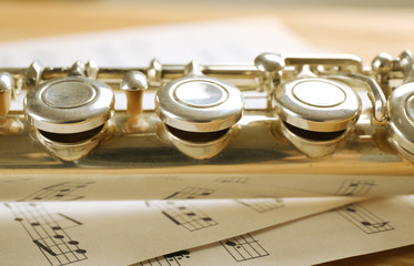 Wall Mural - Silver flute with music notes on table close up