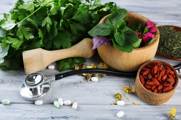 Wall Mural - Alternative medicine herbs and stethoscope on wooden table background