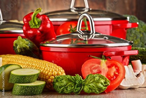 Fototapeta do kuchni Composition with red steel pots and variety of fresh vegetables