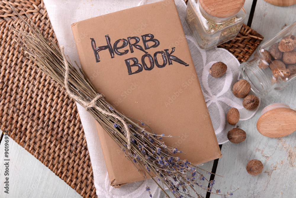 Dry lavender with nutmeg and book on table close up