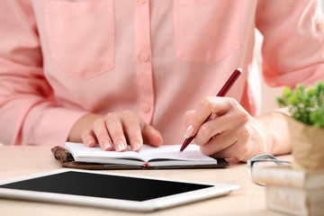 Wall Mural - Woman write on notebook on workplace close up