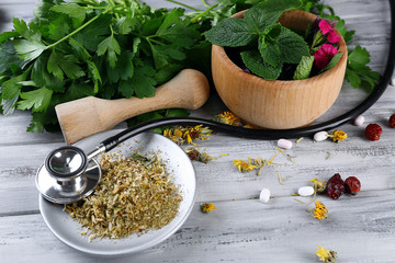 Wall Mural - Alternative medicine herbs, berries and stethoscope on wooden table background