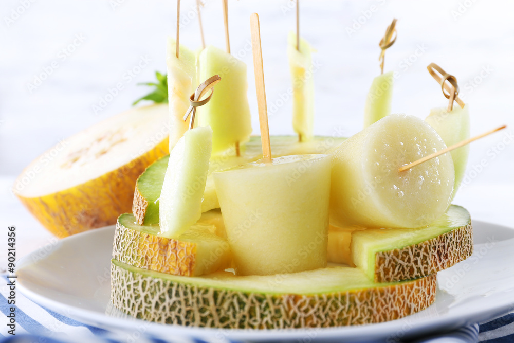 Melon ice lolly on white wooden background