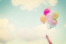 Girl Hand Holding Multicolored Balloons Done With A Retro Vintage Instagram Filter Effect, Concept Of Happy Birth Day In Summer And Wedding Honeymoon Party (Vintage Color Tone)