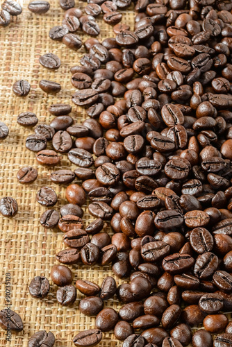 Naklejka ścienna roasted coffee beans on burlap mat