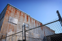 Old Rusted Industrial Building Behind Fence