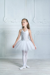 Wall Mural - A little adorable young ballerina in a playful mood in the inter