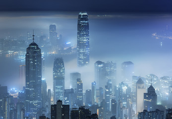 Misty night view of Victoria harbor in Hong Kong city