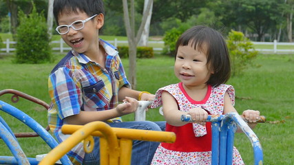 Wall Mural - Asian children on the carousel at the playground in the park 