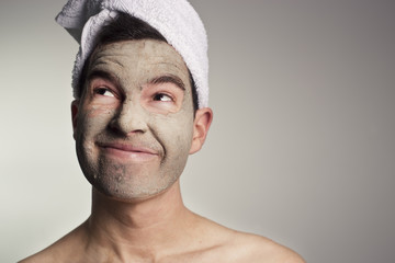 man with a mud mask on this face