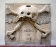 skull and crossbones and crossbones on the outside of a church in Rodi, Gargano Apulia..Note the admonition 