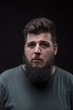 © HD92 - Confused young man with big beard, black background.