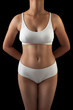 © Prashant ZI - Slim and sexy body of an young Asian woman standing in white bra and pantie isolated on black background.