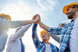 close up of builders in hardhats making high five