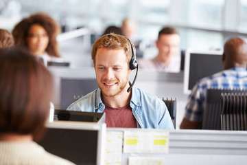 Young man working at a computer in a call centre