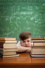 Wall Mural - child studying on desk looking bored and under stress with a tir