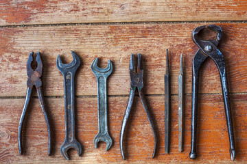 Older tools are laid out in a row on background of the old wooden floor