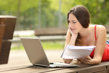 Wall Mural - Student girl studying with a laptop in an university campus