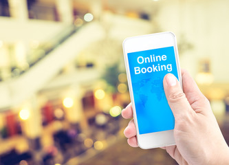 Poster - Hand holding mobile with online booking with blur background, Di