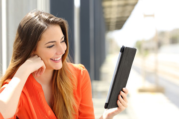 Wall Mural - Woman reading a Tablet or ebook in a train station