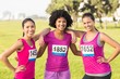 © WavebreakMediaMicro - Three smiling runners supporting breast cancer marathon