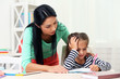 © Africa Studio - Beautiful school girl doing homework with mother at home