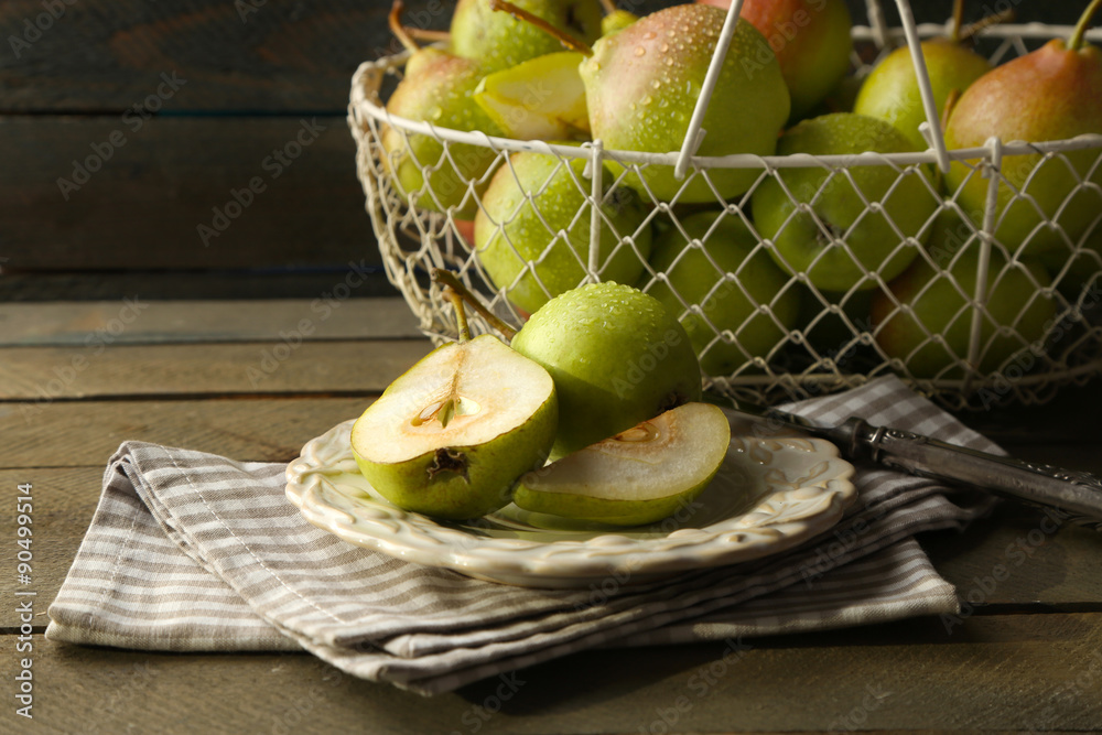 Ripe tasty pears in basket on table close up