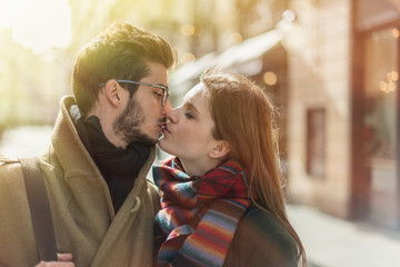 Young romantic couple kissing in the street