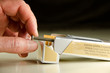 © Michael O'Keene - Closeup of a man pulling a nail out of a pack of cigarettes showing dangers of smoking & reminding us that each cigarettes a nail in your coffin. Smoking cessation and, medical and health promotion.