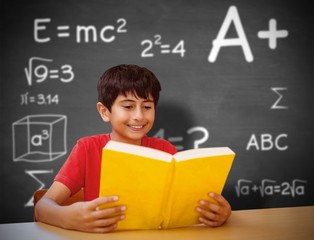 Poster - Composite image of cute boy reading book in library