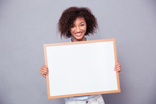Portrait Of A Smiling Afro American Woman Holding Blank Board