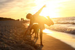 Zabawa przy zachodzie słońca. Dzieci chłopiec i dziewczynka bawią się na brzegu morza podczas zachodu słońca