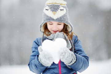 Funny little girl having fun in winter park