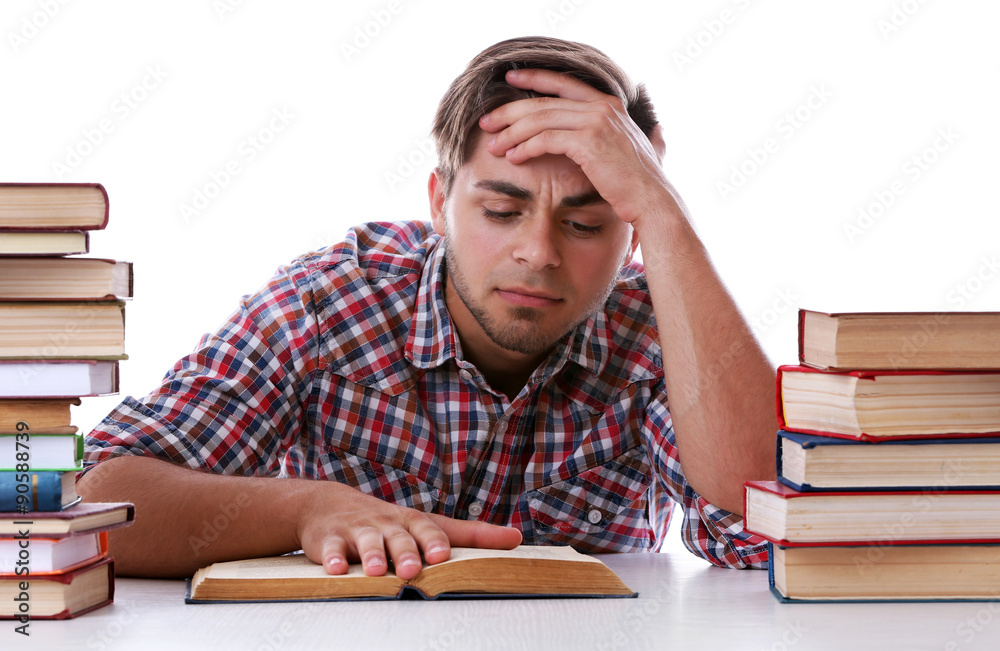 Young man reading book at table on white background